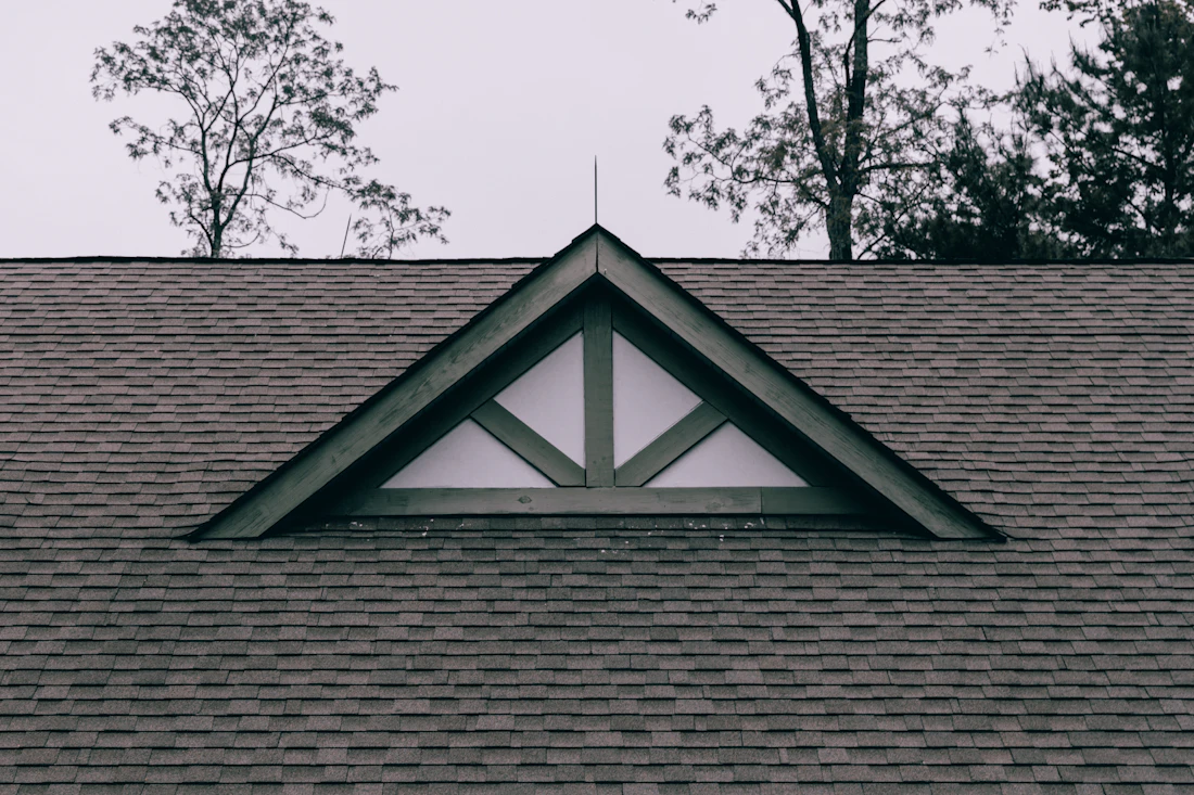 A finished gable and dormer window on a shingled roof